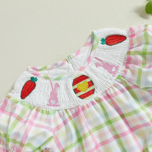 Close-up of checkered ruffle sleeve baby onesie with strawberry and bunny embroidery detail