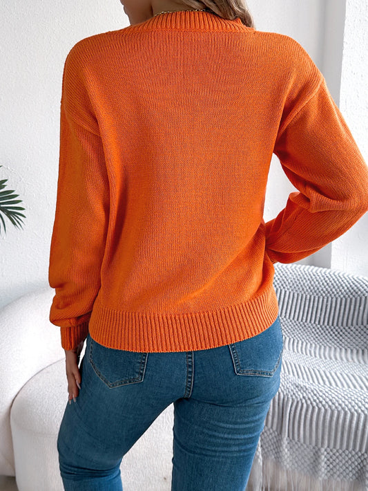 Back view of a cozy women's pumpkin sweater in bright orange, perfect for fall fashion