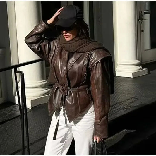Woman wearing EtherealBe half collar faux leather jacket in dark brown belted at waist with scarf cap and white pants