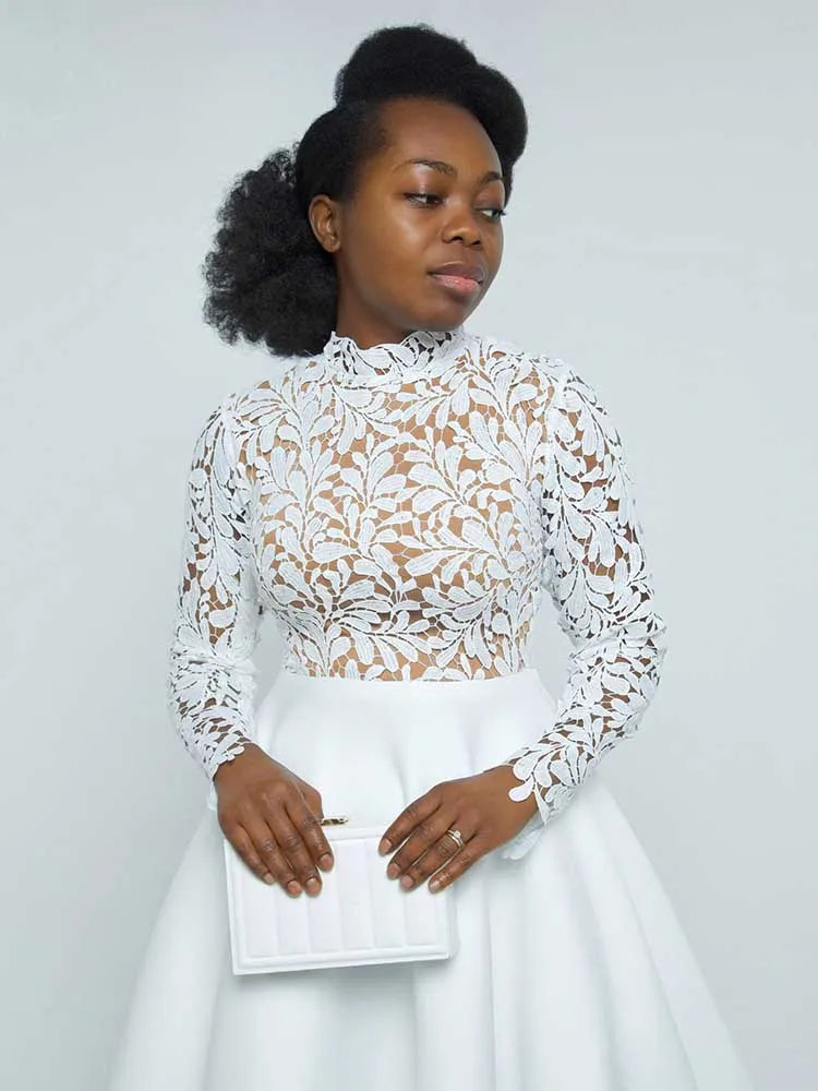 Black woman wearing EtherealBe white floral high neck bodice and full skirt holding clutch elegant lace party dress for women