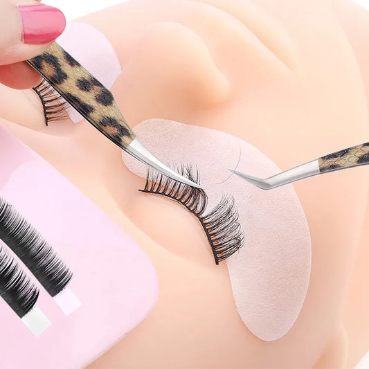 Leopard eyelash extension tweezers being used for lash application on a practice mannequin