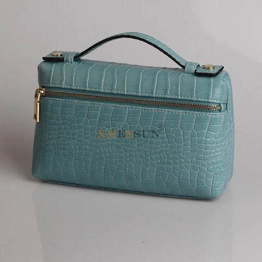 Luxurious faux crocodile makeup bag in teal with a sturdy handle and zip closure