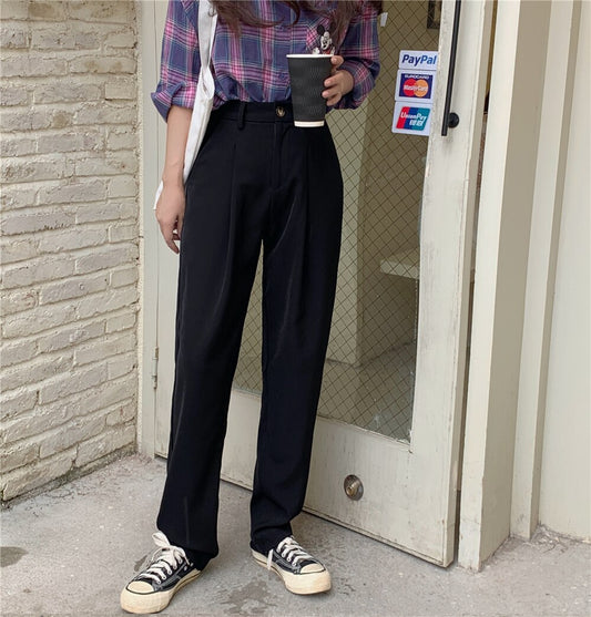 Woman wearing black Formal straight leg suit office trousers for women. Plaid shirt, casual sneakers and coffee cup