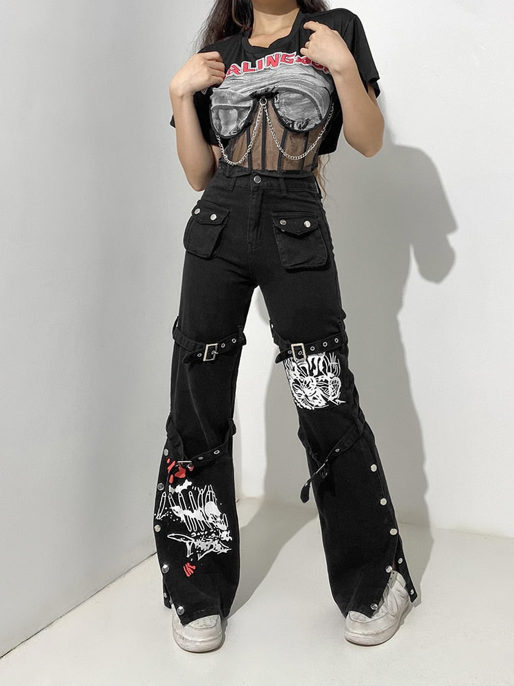 Model wearing black mall goth cargo pants women with buckles straps graffiti patches high waist wide leg