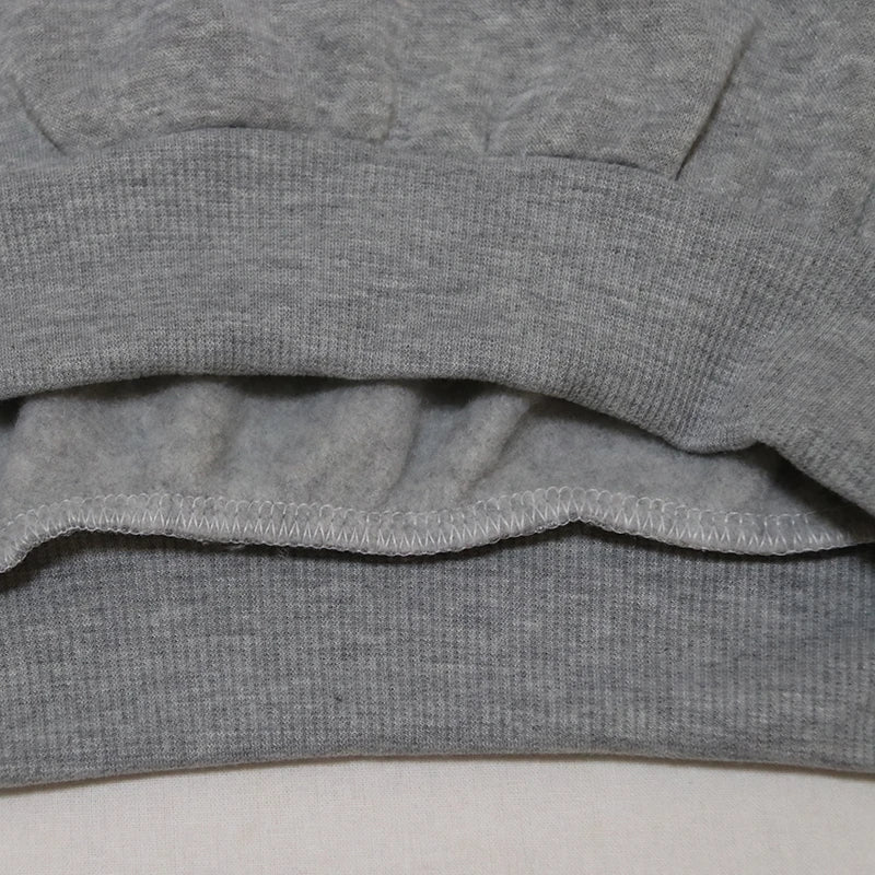 Close-up of the hem of a grey Halloween witch hat sweatshirt for women highlighting soft fabric details