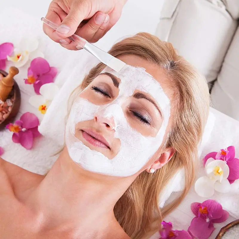 EtherealBe facial mask applicator brushes in use for a spa treatment on a woman with a facial mask