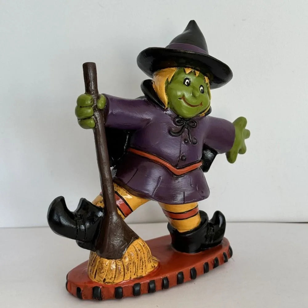 Colorful Halloween witch figurine with a broomstick, dressed in purple and orange attire