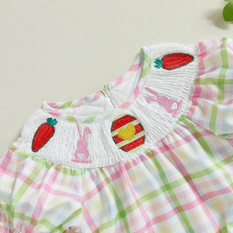 Close-up of checkered ruffle sleeve baby onesie with strawberry and bunny embroidery detail