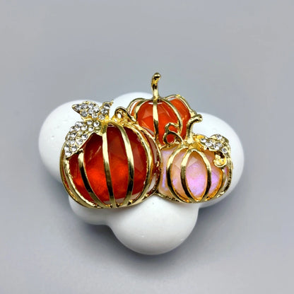 EtherealBe Halloween brooch pins featuring three colorful pumpkin designs with gold detailing