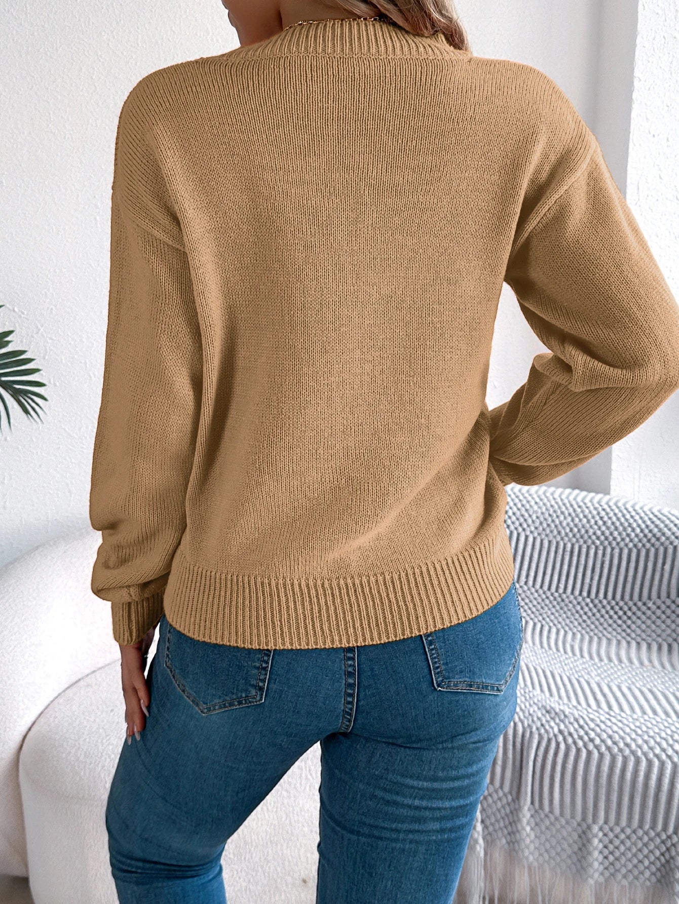 Back view of a cozy women's pumpkin sweater in tan color, perfect for fall fashion.