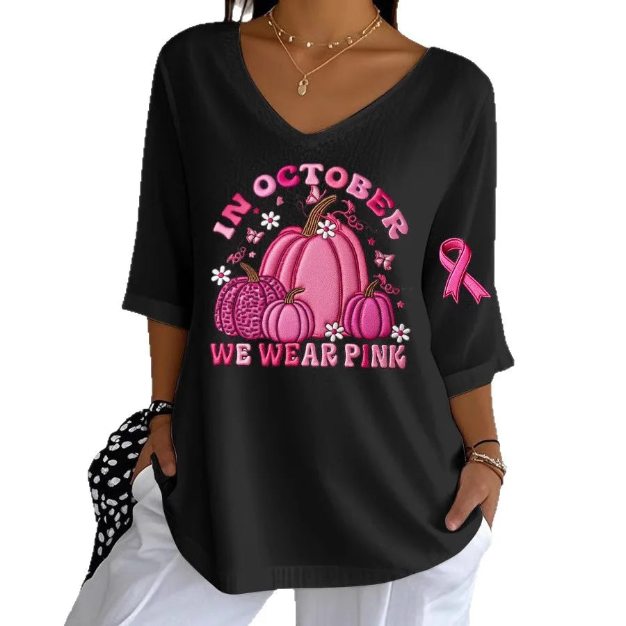 Women's Halloween graphic t-shirt in black featuring pink pumpkins and breast cancer awareness ribbon