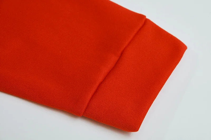 Close up of orange sleeve cuff detail of spider web zipper hoodie for women showing ribbed cuff and smooth knit