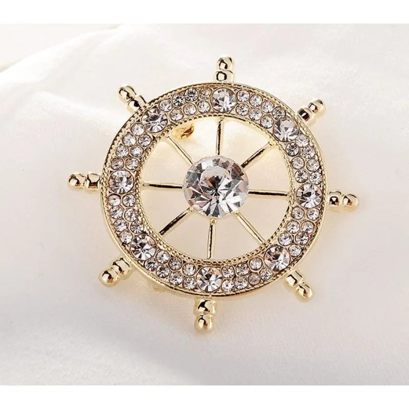 Nautical style crystal brooch featuring a ship's wheel design with sparkling rhinestones