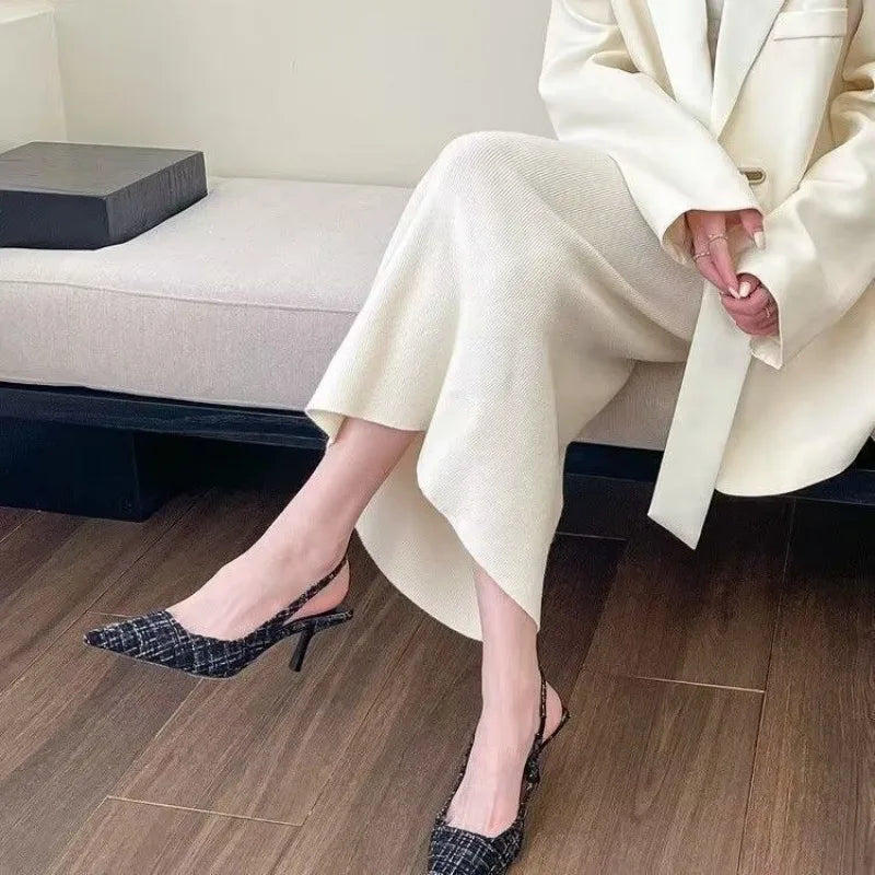 EtherealBe stylish black stilettos for wide feet worn with a chic outfit on a sofa