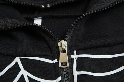 Close up of black spider web zipper hoodie for women showing metal zipper and white web print on fabric