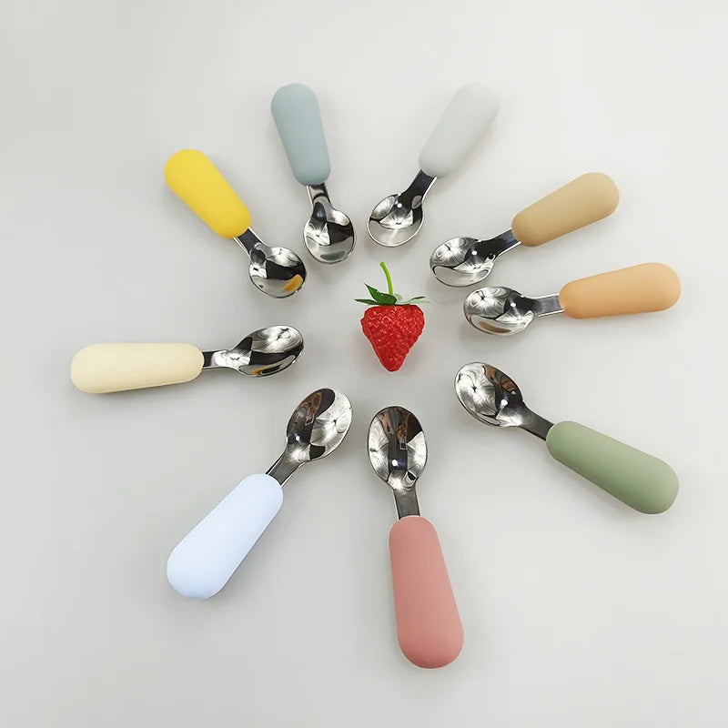 Colorful stainless steel baby utensils set featuring soft grip handles in various shades for easy feeding