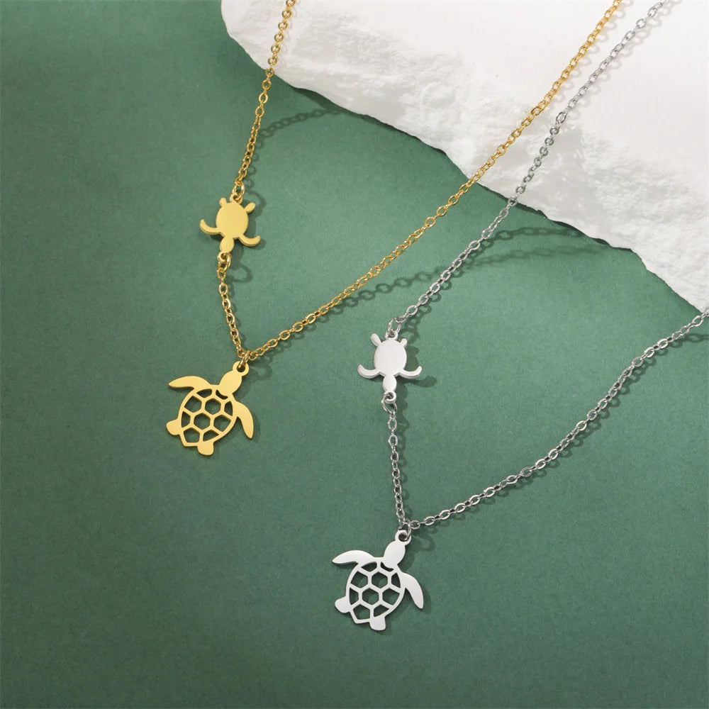Gold and silver sea turtle pendant necklaces for women displayed on a green background