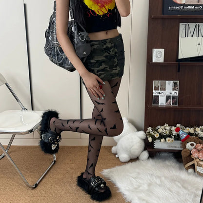 Stylish Halloween bat pattern tights for women paired with a crop top and camo mini skirt