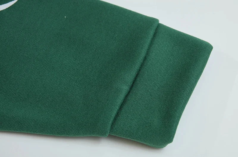 Close up of green spider web zipper hoodie for women sleeve cuff ribbed knit fabric and quality stitching