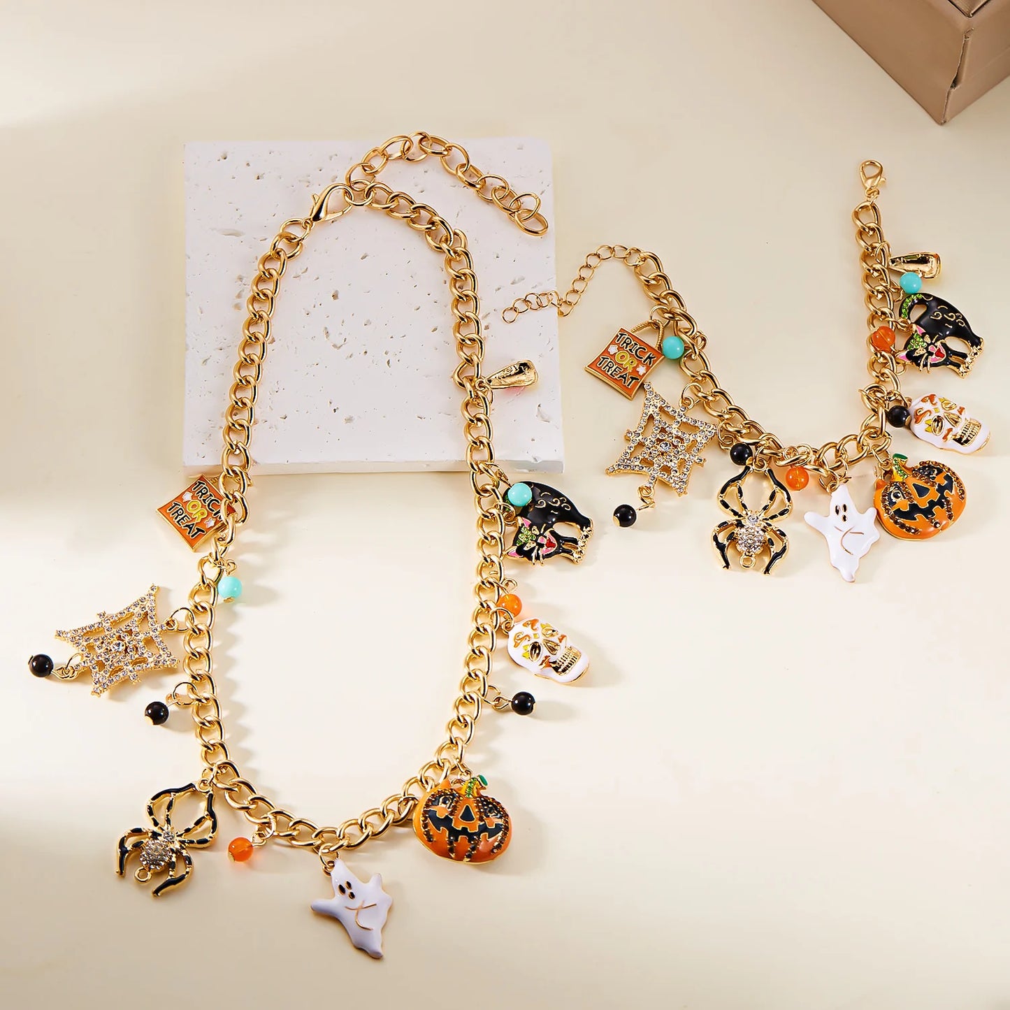 Halloween pumpkin necklace and bracelet set featuring gold chains and colorful charms for festive jewelry
