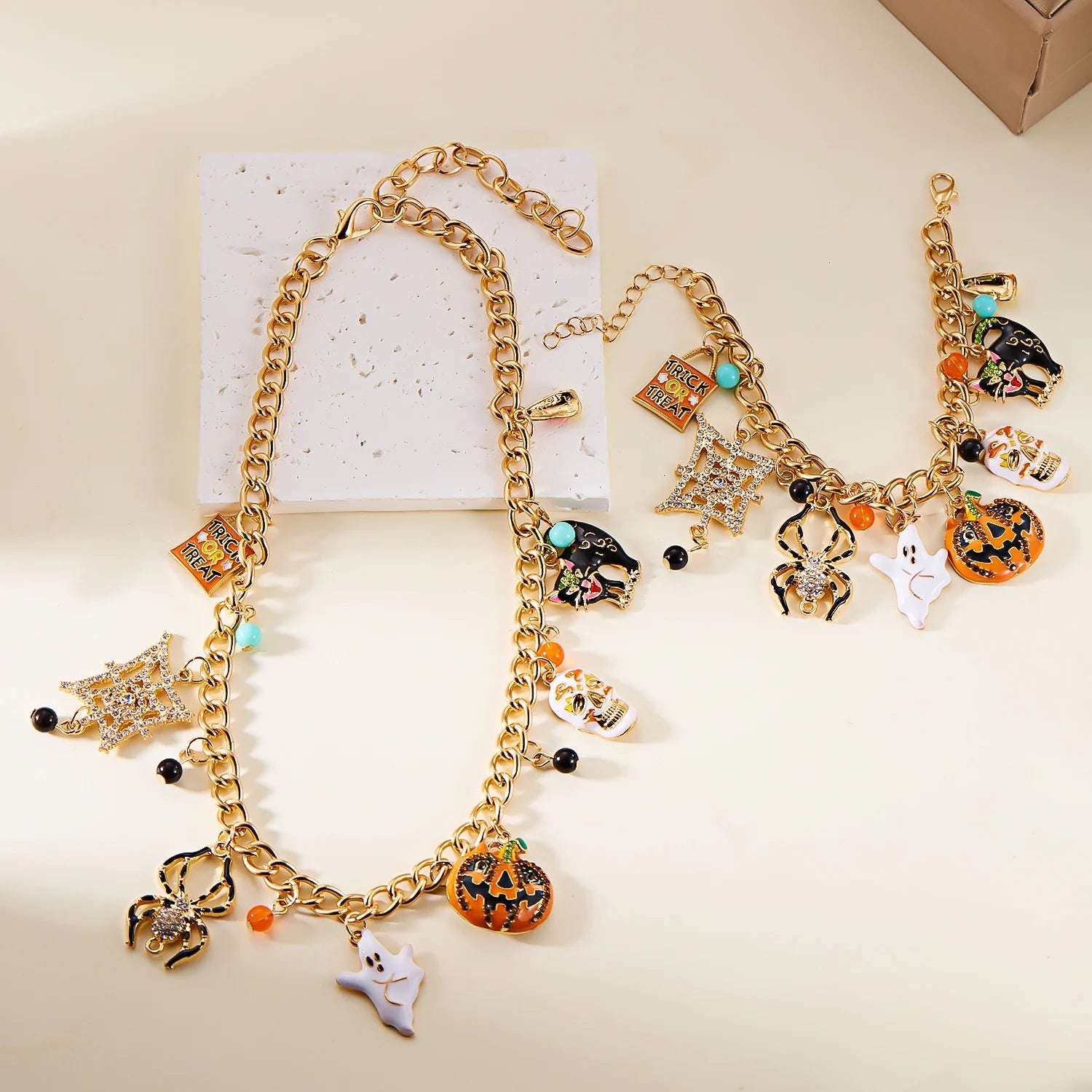 Halloween pumpkin necklace and bracelet set featuring gold chains and colorful charms for festive jewelry
