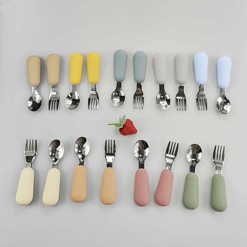 Colorful stainless steel baby utensils set featuring soft grip handles and matching forks and spoons