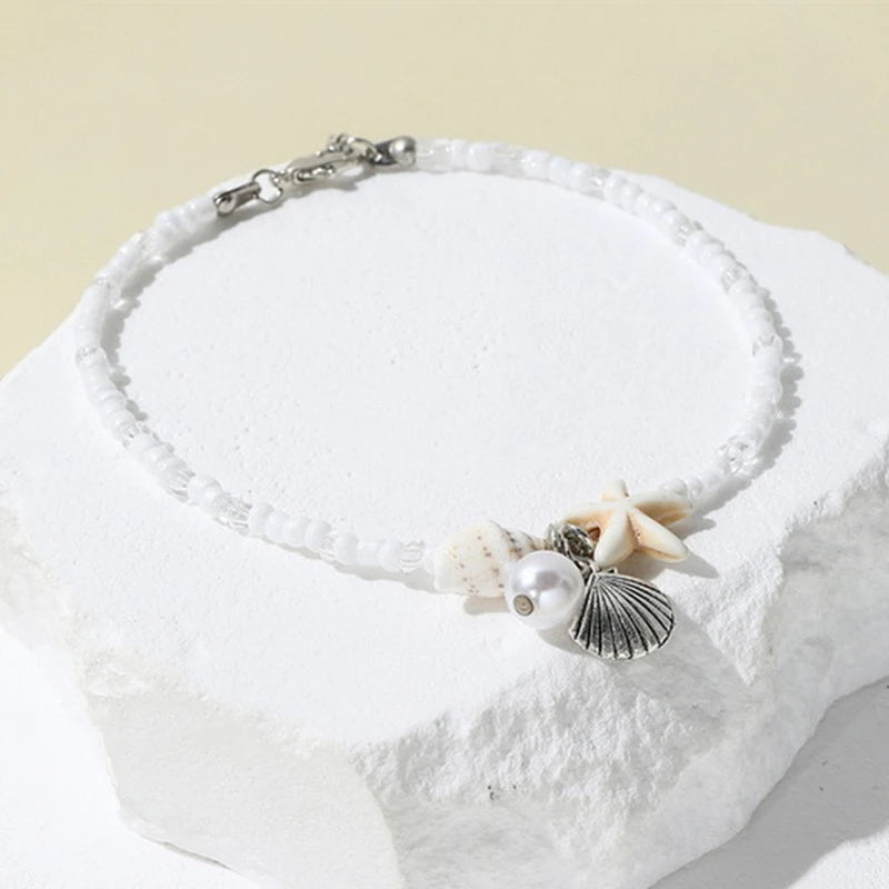 EtherealBe bohemian beach bracelet with seashells and pearl on a white background