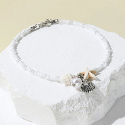 EtherealBe bohemian beach bracelet with seashells and pearl on a white background