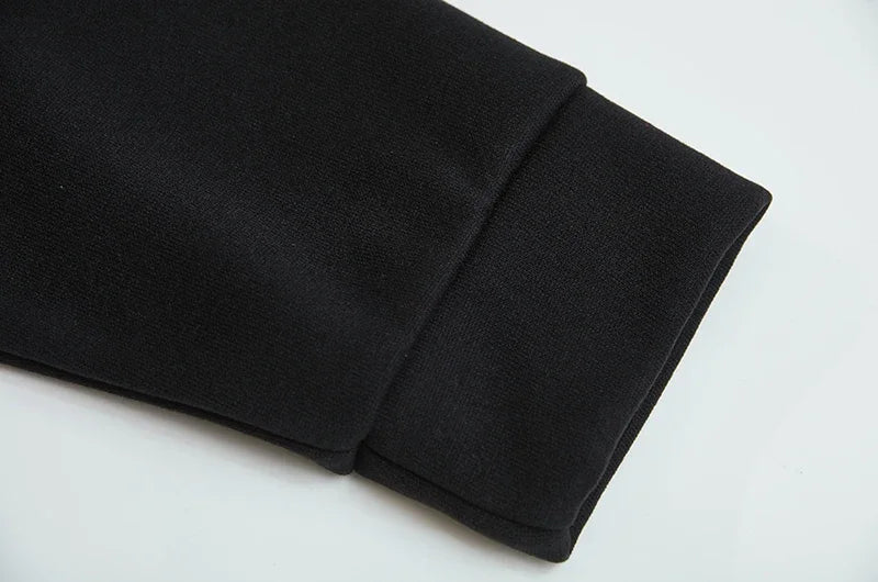 Close up of black spider web zipper hoodie for women showing sleeve cuff ribbing and hem detail on white background