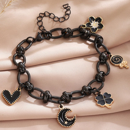 EtherealBe Halloween charm bracelet for women featuring black and gold charms including a crescent moon and heart