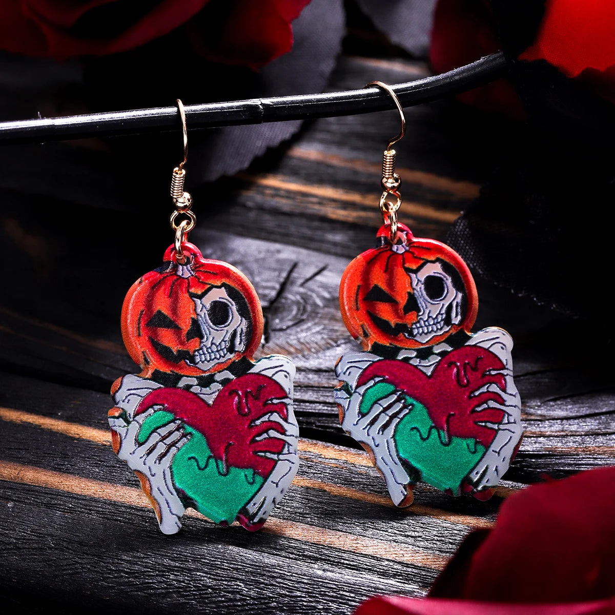 Colorful Halloween earrings for women featuring a skeleton holding a pumpkin and heart design