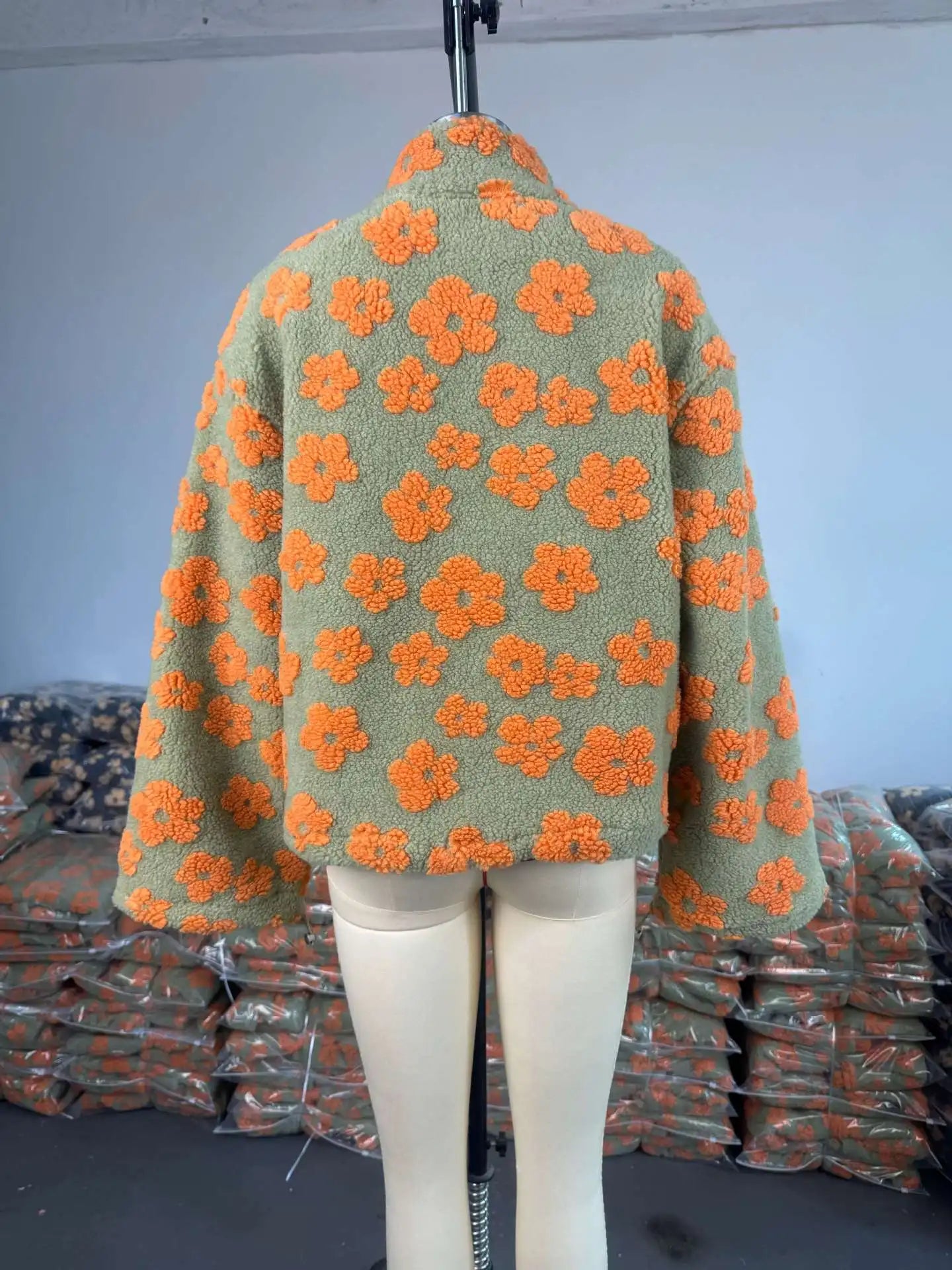 EtherealBe cozy lambskin coat for women in green with orange floral pattern on a mannequin
