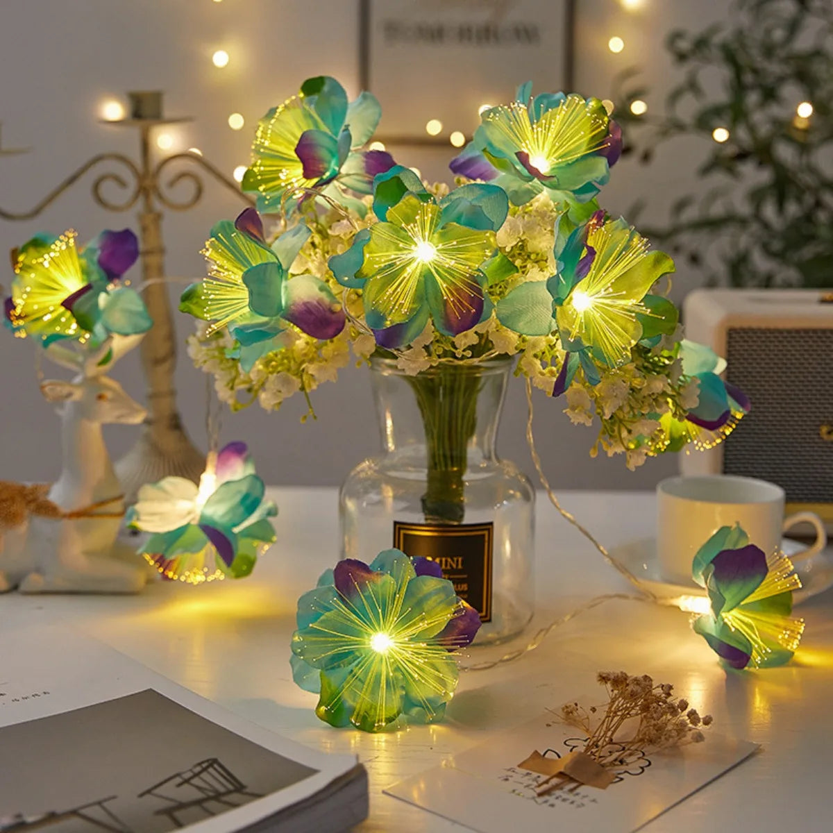 EtherealBe fairy flower string lights illuminating a floral arrangement on a cozy table setting