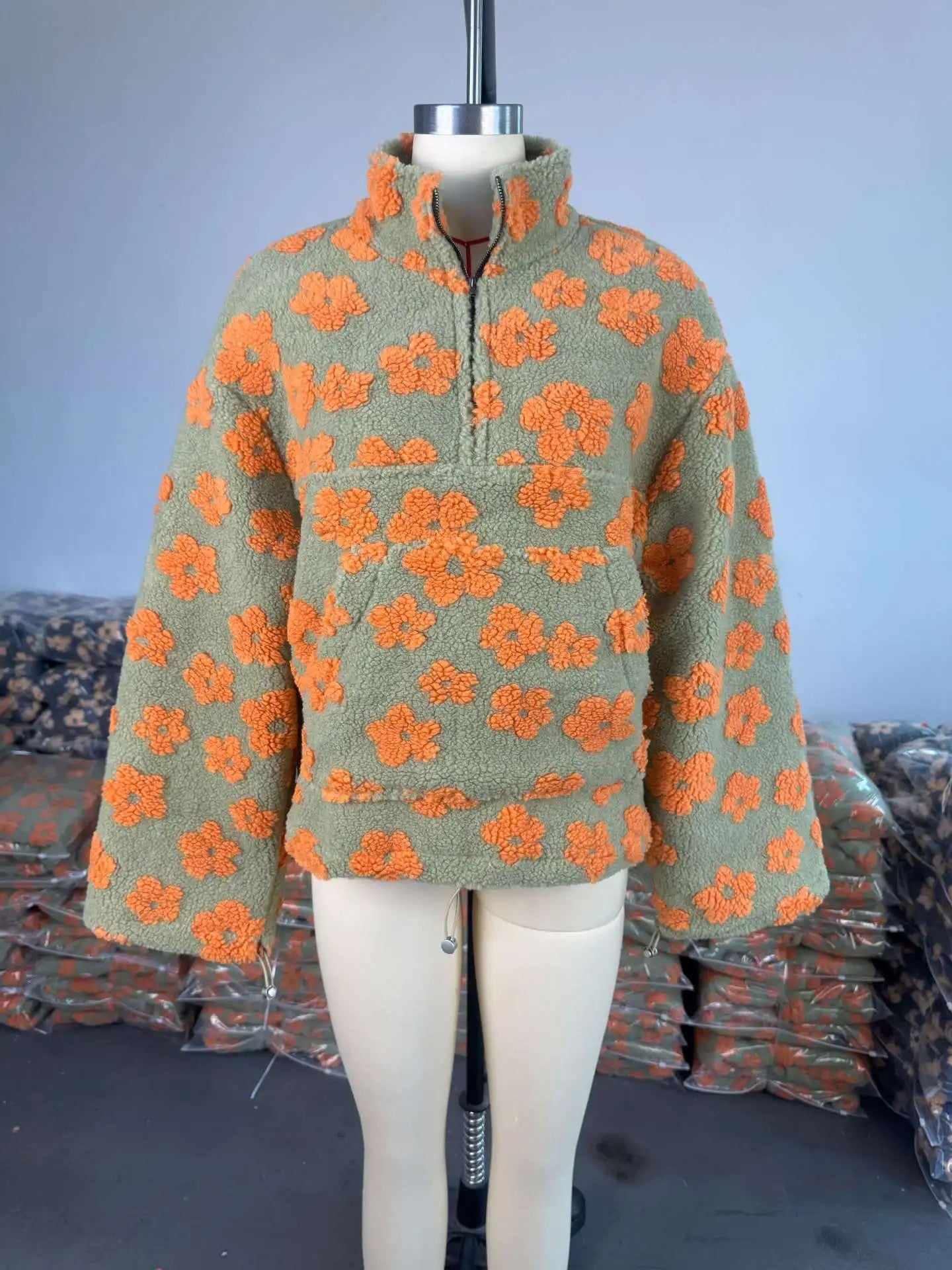 Stylish floral pullover with orange flowers on a green background, perfect for fall outfits