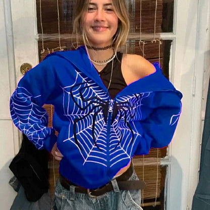 Blue spider web zipper hoodie for women styled off shoulder on smiling model with black tank and jeans
