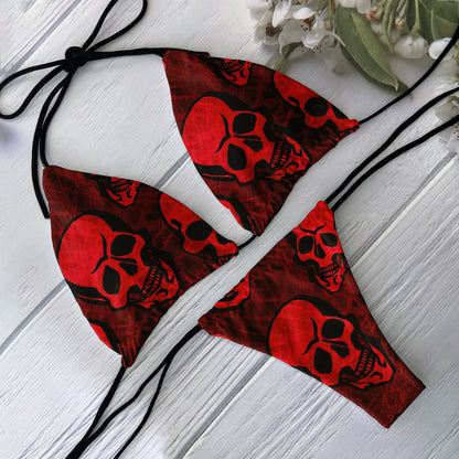 Red skull print bikini set with black tie triangle top and cheeky bottom on white wood background
