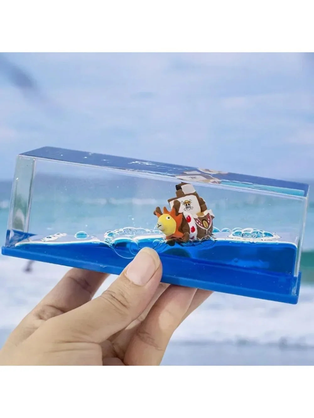 Handheld One Piece Thousand Sunny drift bottle decorative toy showing miniature ship on blue waves in clear case