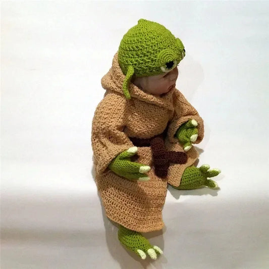 Adorable baby in a baby yoda crochet costume set featuring green hood and soft robe