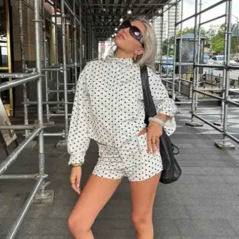 Woman wearing EtherealBe casual chic polka dot matching set white long sleeve top and shorts with black bag in city