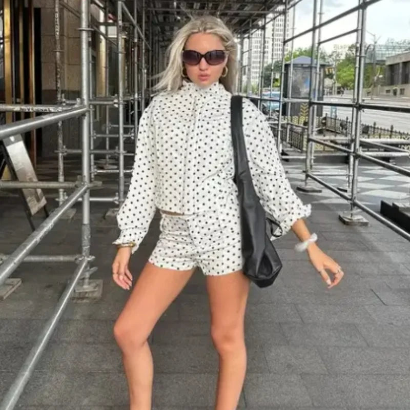 Model wearing EtherealBe casual chic polka dot matching set white long sleeve blouse and shorts with black shoulder bag