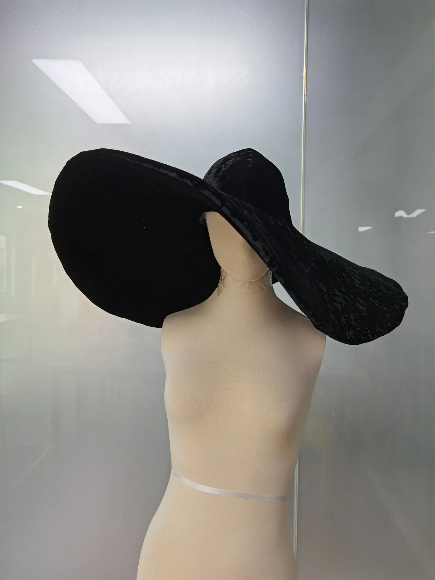 Elegant black velvet large brim hat displayed on a mannequin for stylish fashion enthusiasts