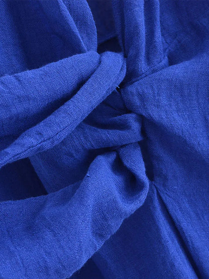 Close-up of blue halter backless summer dress showcasing soft fabric and stylish knot detail.
