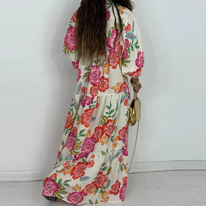 Back view of woman wearing an elegant printed v-neck maxi dress cream with bold pink orange floral tiers and puff sleeves