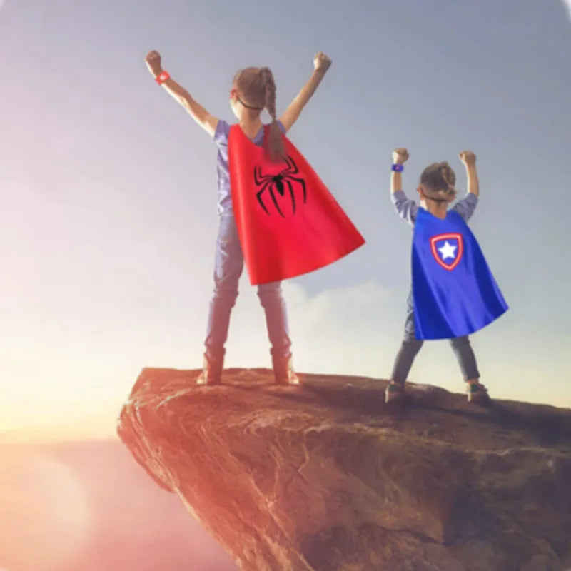Kids wearing capes on a cliff, one in a red Spider costume and the other in a blue Captain America costume for kids