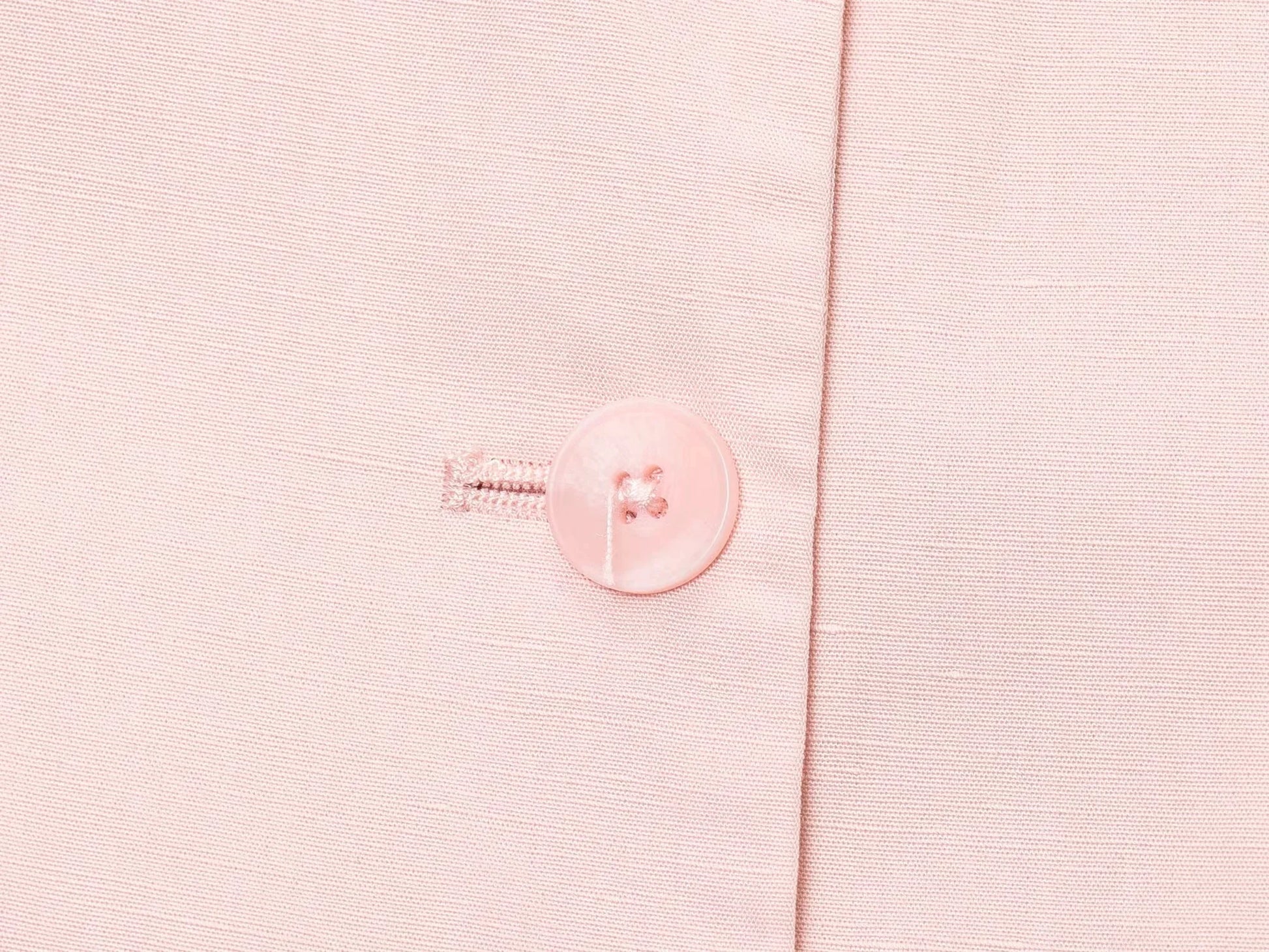 Close-up of pink button detail on casual chic office lady pantsuit fabric