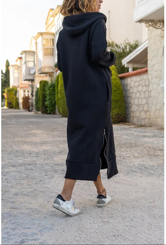 Model wearing a casual hooded V-neck dress in black with a relaxed fit and side slits