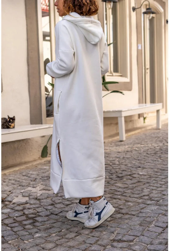 Woman wearing a white casual hooded V-neck dress with side slits for a stylish, relaxed look