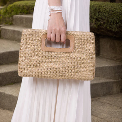 Chic straw woven shoulder bag held by a model in elegant attire, ideal for summer outings