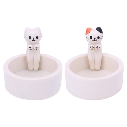 Set of two cute cat tealight holders featuring playful cat figurines in a white base