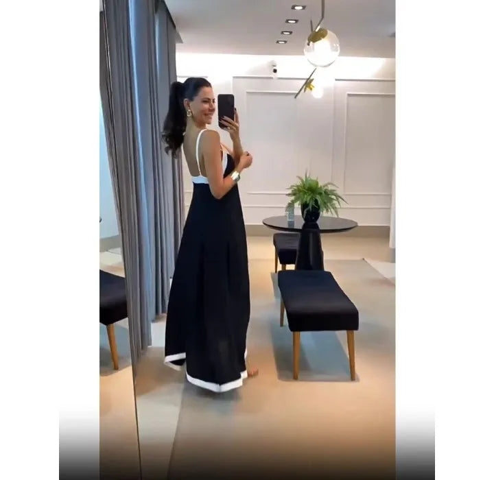 Model wearing a black and white sleeveless maxi dress in a stylish boutique setting